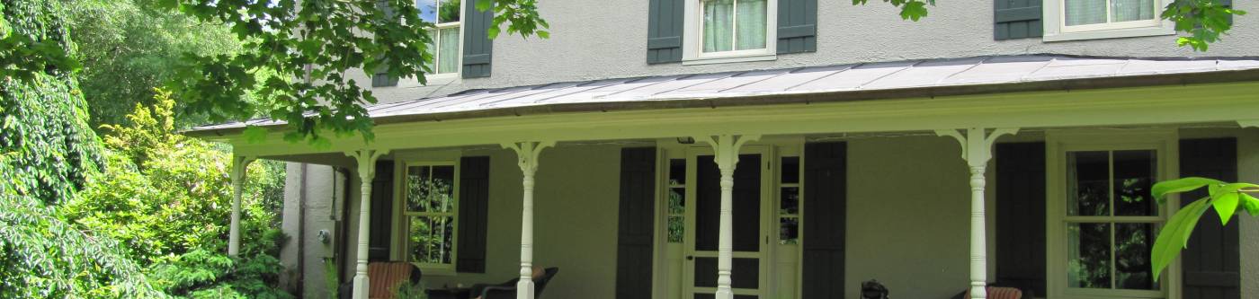 The front of a beautiful country home in Charlottesville, with vibrant green surroundings for extended stay accommodations